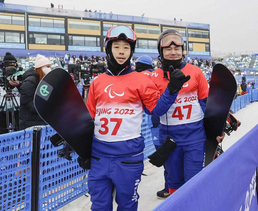 男子バンクドスラローム下肢障害の競技を終え、引き揚げる際にカメラに向かってポーズをとる岡本圭司（左）と市川貴仁