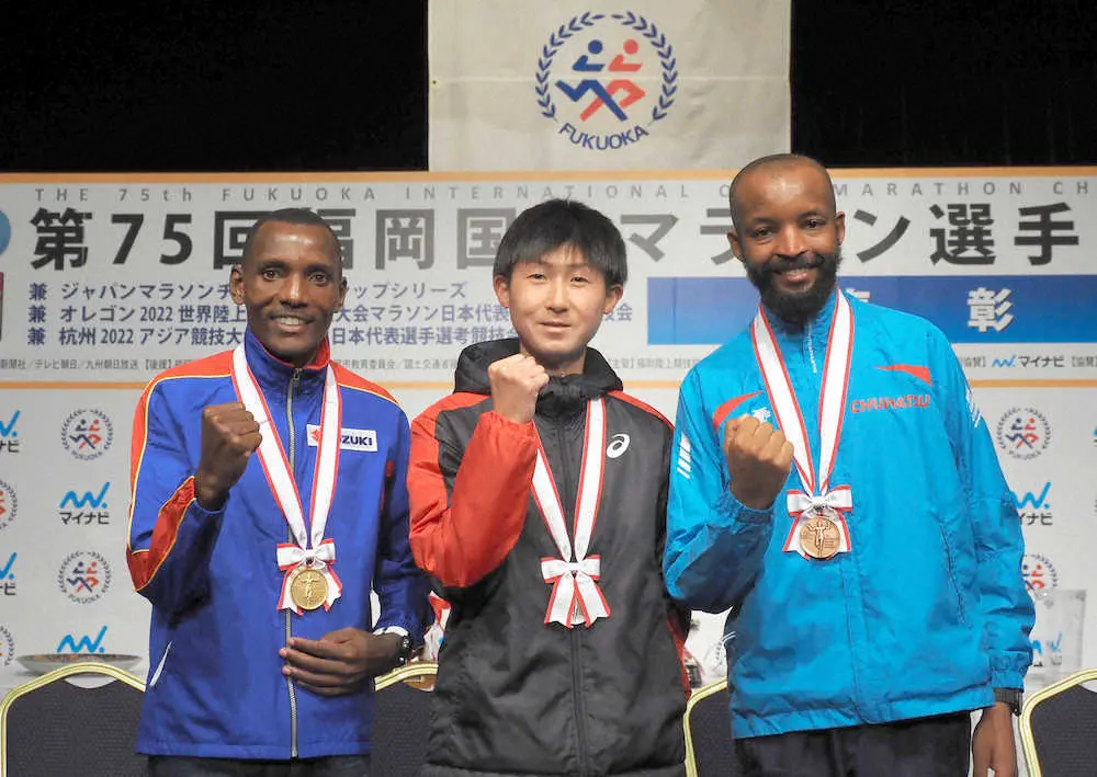 昨年の福岡国際マラソン閉会式で笑顔をみせる（左から）1位のギザエ、2位の細谷、3位のルンガル