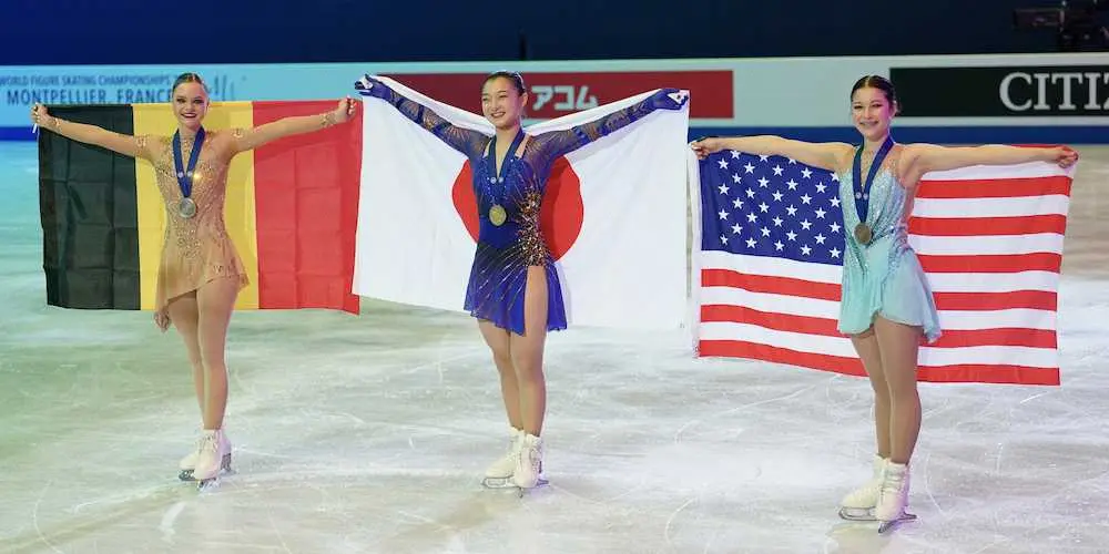 ＜世界フィギュア2022　女子フリー＞表彰式を終え国旗を翻す左からヘンドリクス、坂本、リウ（撮影・長久保　豊）