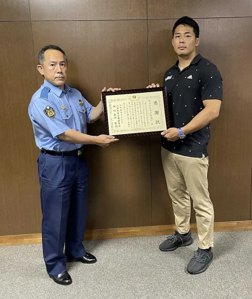 兵庫県葺合警察署の植田賢治署長（左）から神戸製鋼所を代表して感謝状を受け取るラグビー部の橋本大輝主将