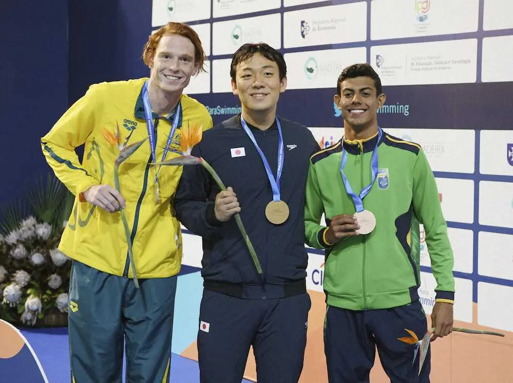 男子100メートル平泳ぎ（知的障害）で優勝した山口尚秀（中央）