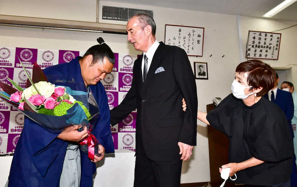 サプライズで登場し引退会見を行った松鳳山（左）に激励の花束を贈呈する先代松ケ根親方（現荒磯、元大関若嶋津）。右はみづえ夫人