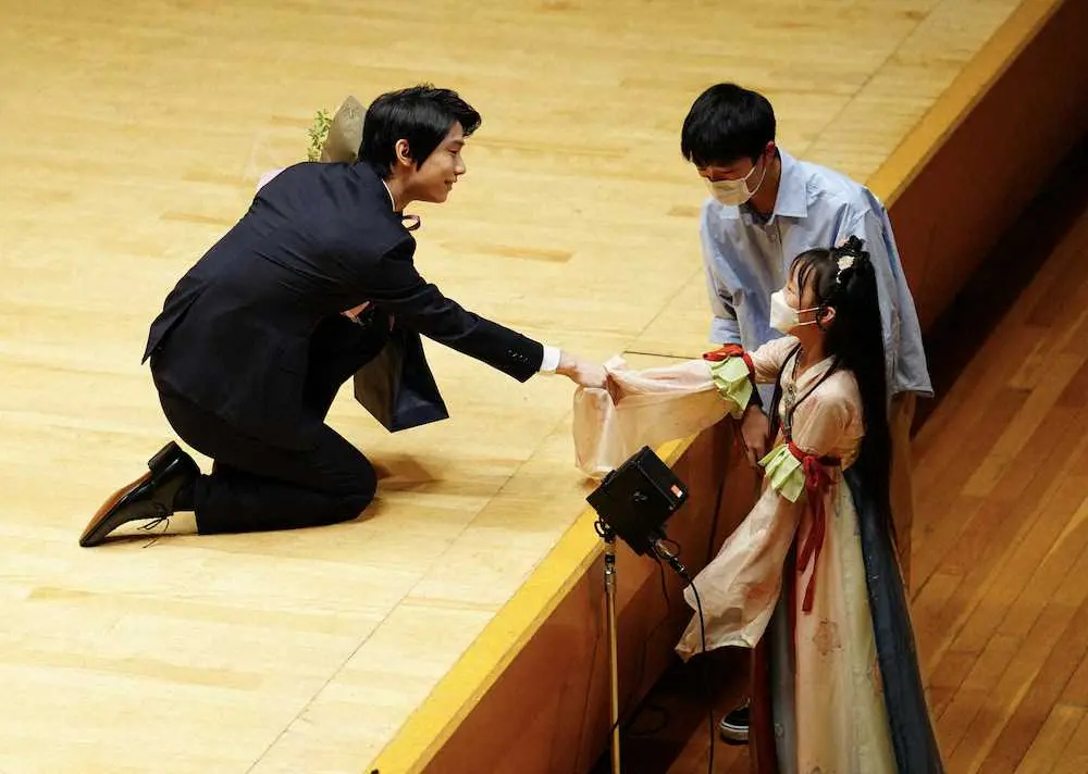 29日の「日中国交正常化50周年慶典」で、舞台下から子供たちに花束をもらいひざまずき握手する羽生結弦さん（撮影・長久保　豊）