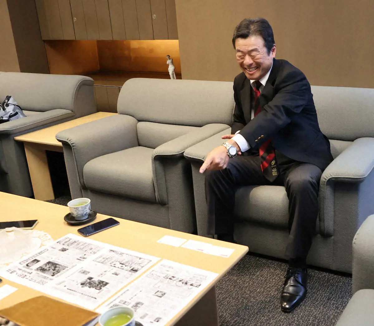 【画像・写真】＜ラグビー早慶戦100回記念企画＞当時のスポニチの紙面のコピーを見て笑う早大ラグビー部OBの広野氏（撮影・篠原岳夫）