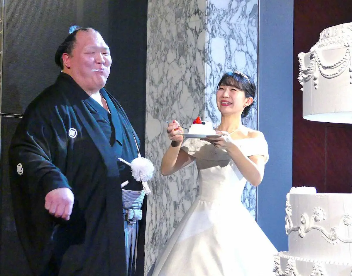 ウエディングケーキを頬張り笑顔の北勝富士と真美夫人（撮影・前川　晋作）