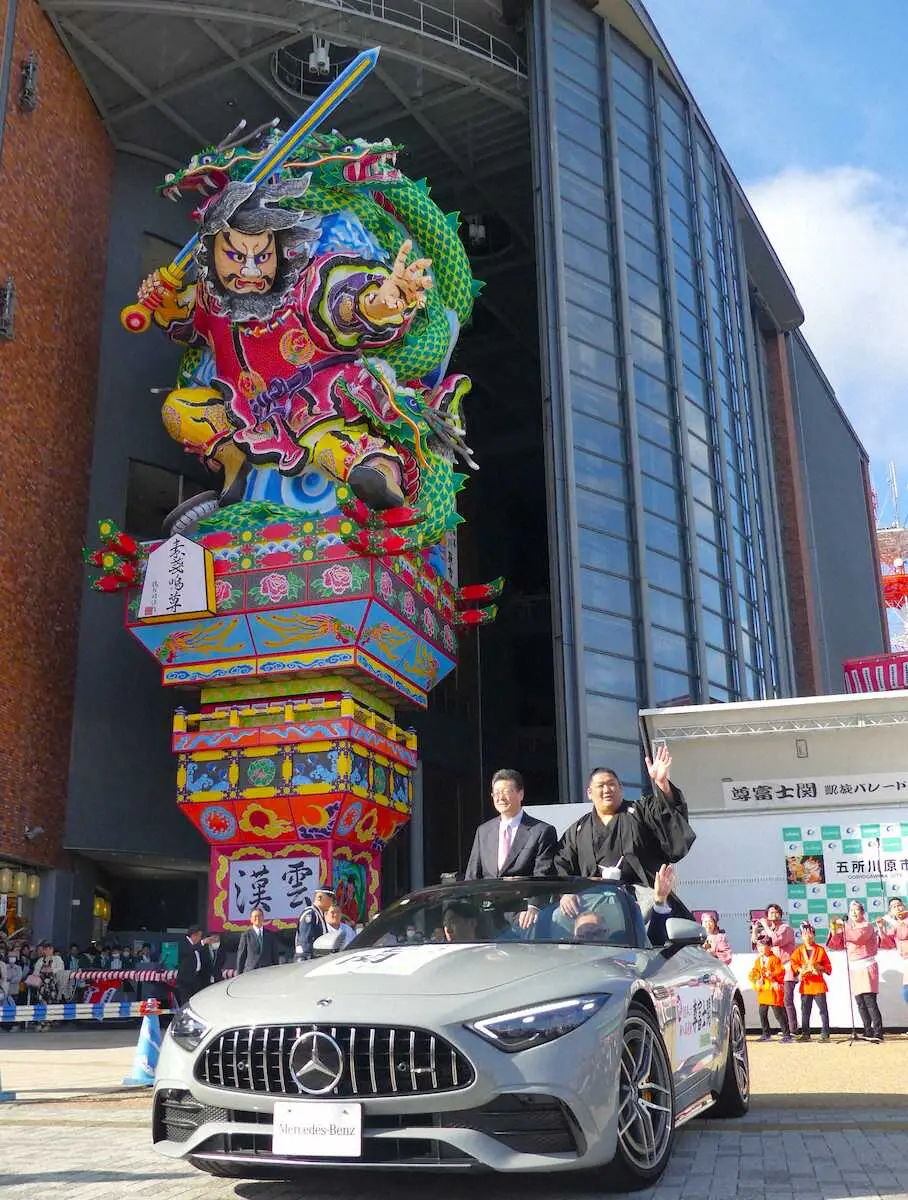 【画像・写真】五所川原市の立佞武多の館の前から出発する尊富士（右）と伊勢ケ浜親方