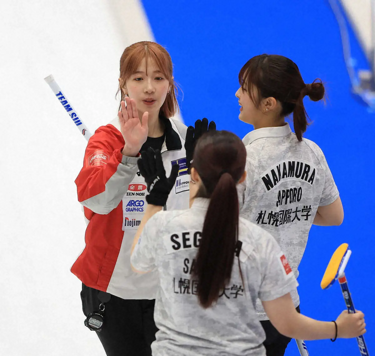 【画像・写真】＜チーム大阪・札幌国際大＞第5E、札幌国際大・敦賀（左奥）は瀬川（手前）、中村とハイタッチをかわす（撮影・西川祐介）