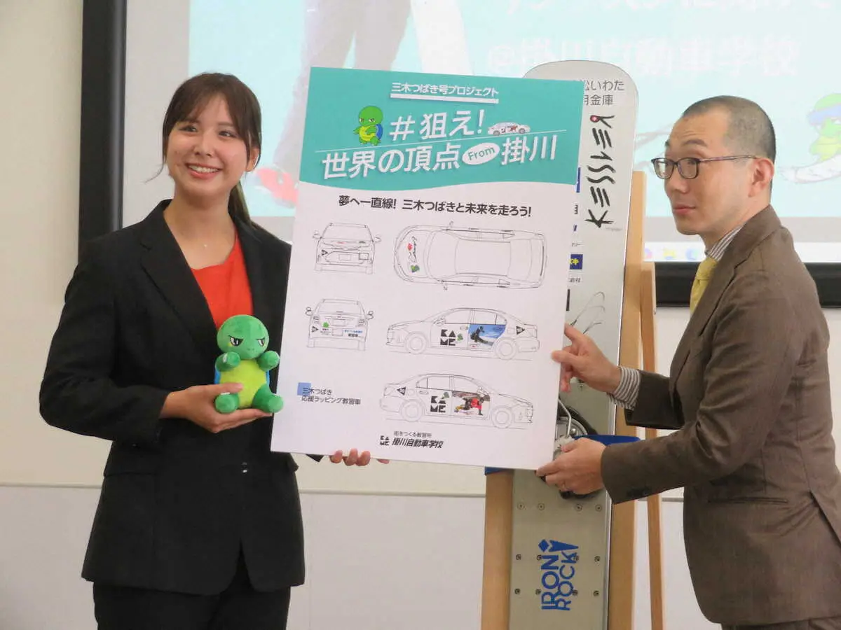 【画像・写真】掛川自動車学校で行われた壮行会で、ラッピング教習車「三木つばき号」のイメージ図を手に笑顔の三木つばき（左）